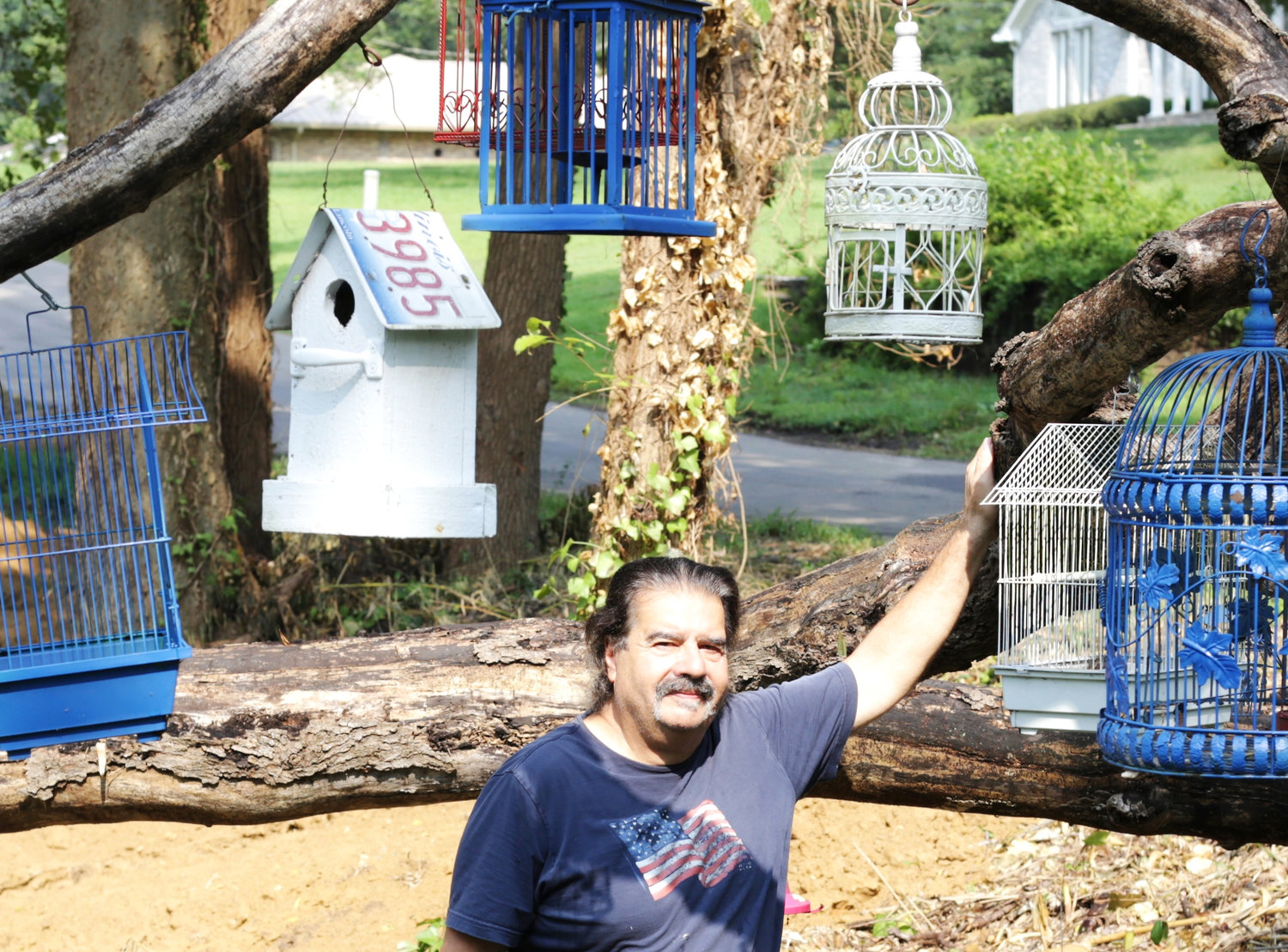 Charles Ambrosino stands at his birdcage tree just north of Mineola. His yard art is among some of the interesting displays around the county. See story Page 2A.